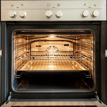 A shiny oven with the door open and light on inside
