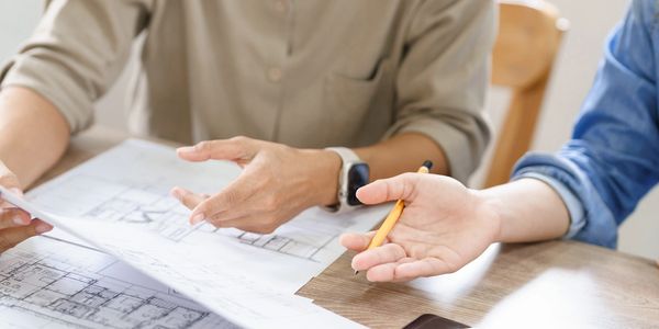 Two people looking over a set of project blueprints