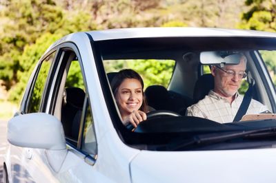 Female driving a car with a male instructor in the passenger seat