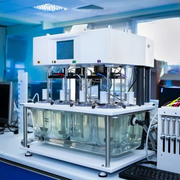 Automated laboratory equipment with multiple glass containers for testing.