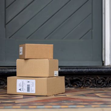 Stack of three cardboard boxes on a doorstep.