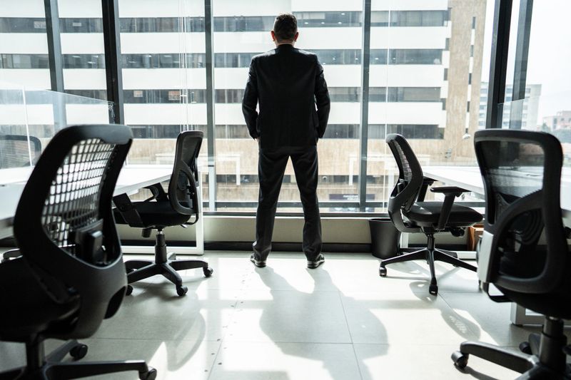 Rear view of a businessman looking through the window at office