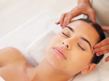 Woman enjoying head massage for relaxation.