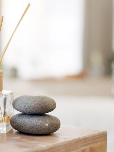 Two balancing gray stones on a wooden surface.