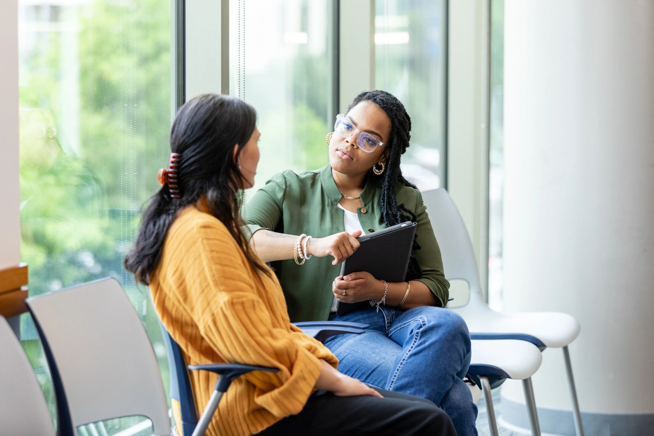 Two women having a serious conversation indoors.