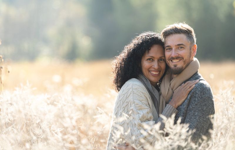 A Latino girl and a white man in love are hanging out, in the tall grass, in solitude in pristine nature. They are dancing in the grass.