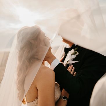 Bride and groom sharing an intimate moment under the veil.