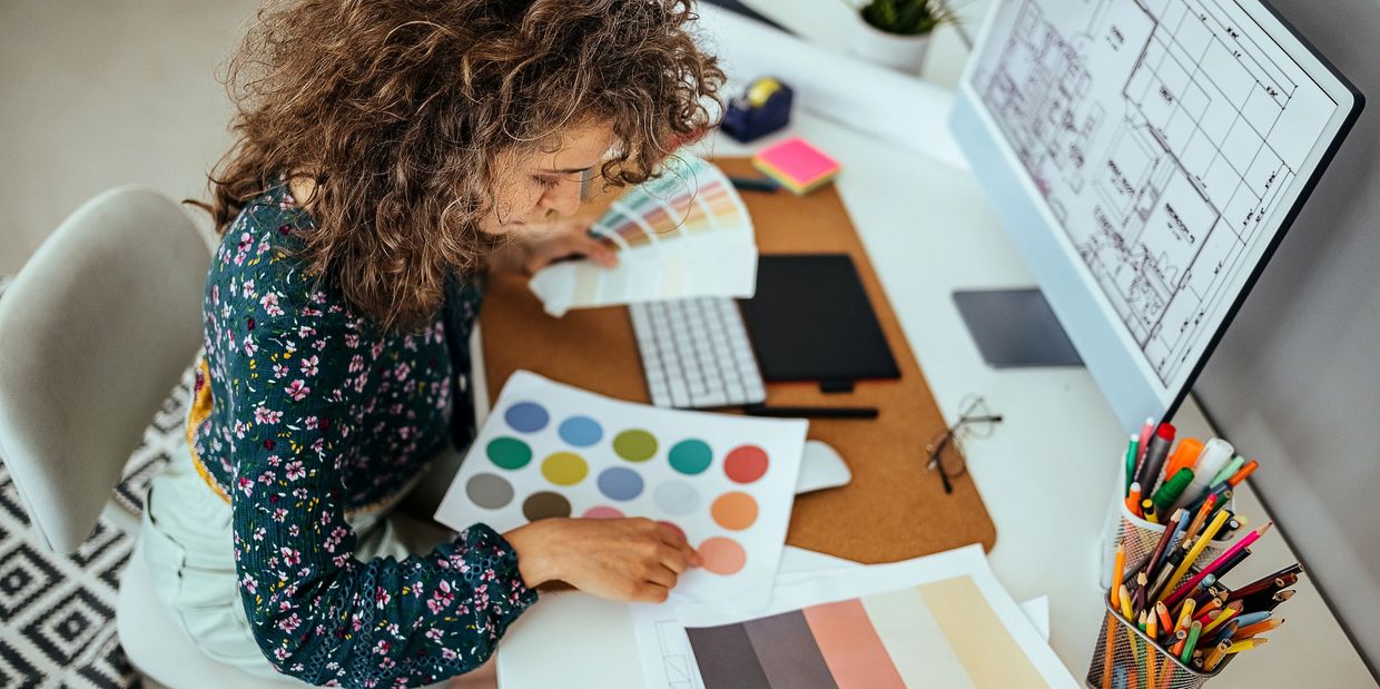 Woman choosing colors for design project at desk.