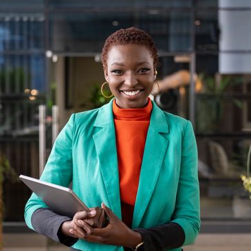 Smiling woman holding a tablet indoors.