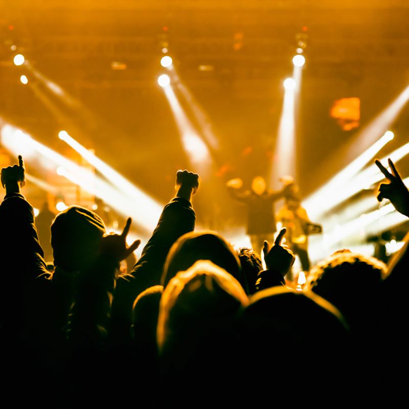 Crowd cheering and watching a band on stage, shallow DOF.