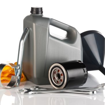 Car maintenance tools and oil filter with funnel and wrench.