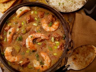 Shrimp gumbo with rice and bread on the side.