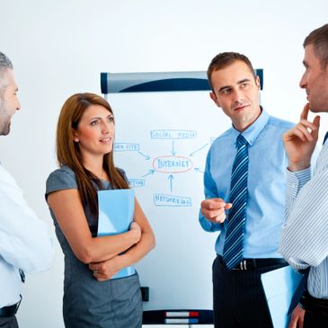 Three professionals discussing work in a modern office space.