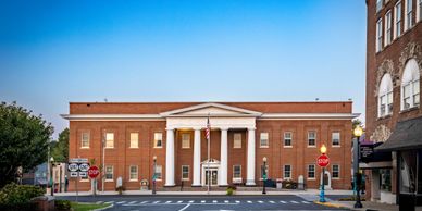 Historic brick courthouse with white columns under a clear blue sky.