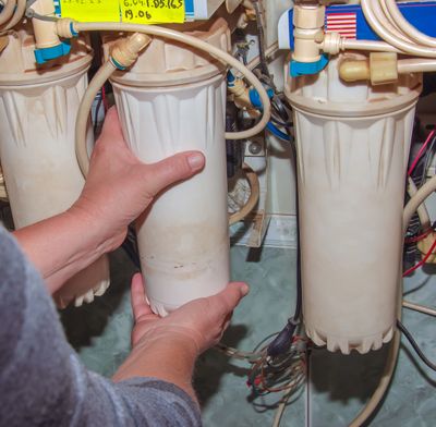 Person repairing calcite and softener cylinders on a well system