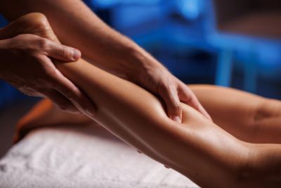 Person receiving leg massage on a massage table.