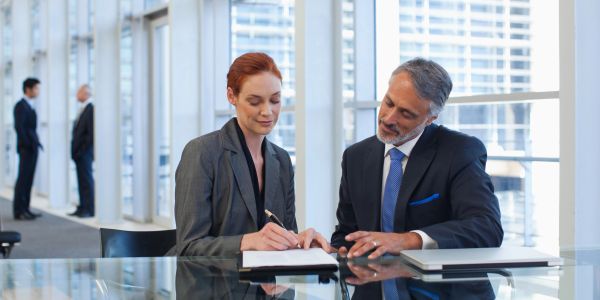 Two business professionals reviewing documents in an office.