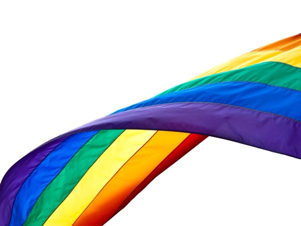 Flowing rainbow pride flag against white background.