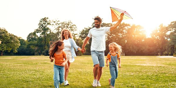 family flying a kite in a park