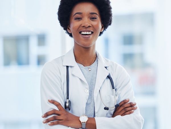 Smiling female doctor with arms crossed and stethoscope.