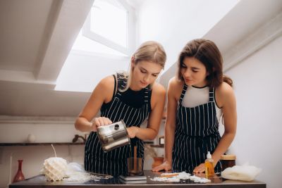 Two women in striped aprons baking together.