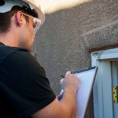 Man inspecting building and taking notes.