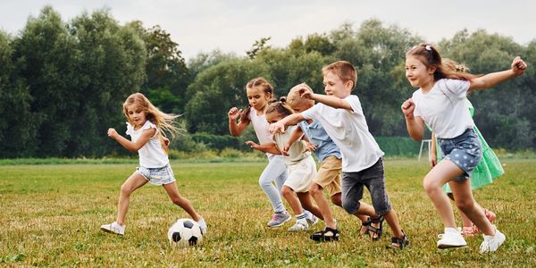 a group of children kicking a soccer balll