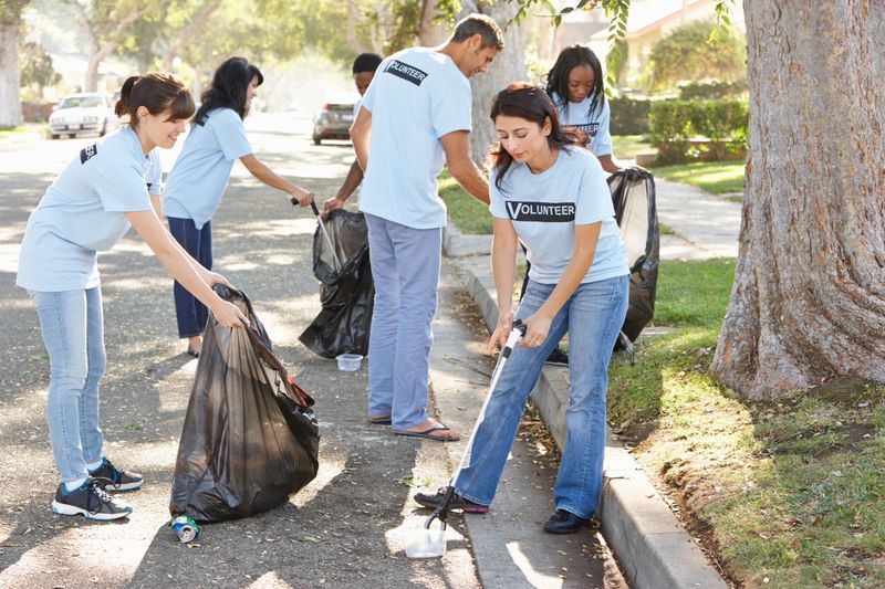 Team Of Volunteers Picking Up Litter In Suburban Street