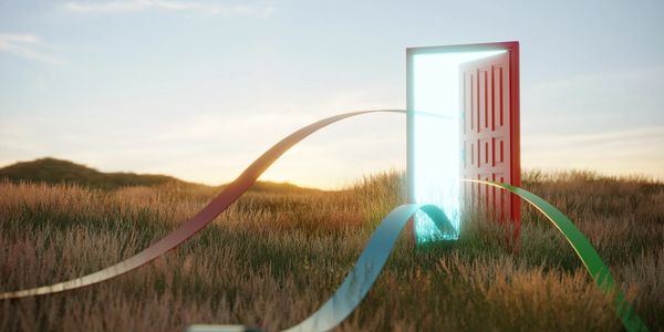 A glowing open door with colorful ribbons in a grassy field at sunset.