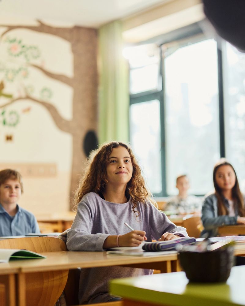 Smiling schoolgirl paying attention during a class at elementary school.