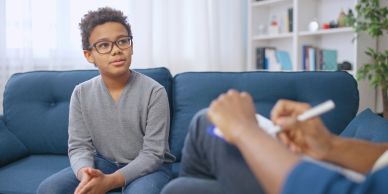 Young boy attentively talking during a therapy session.