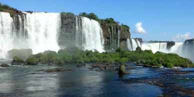 Beautiful waterfall with greenery and blue sky.
