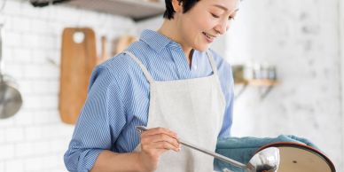 Woman cooking with a ladle in the kitchen.