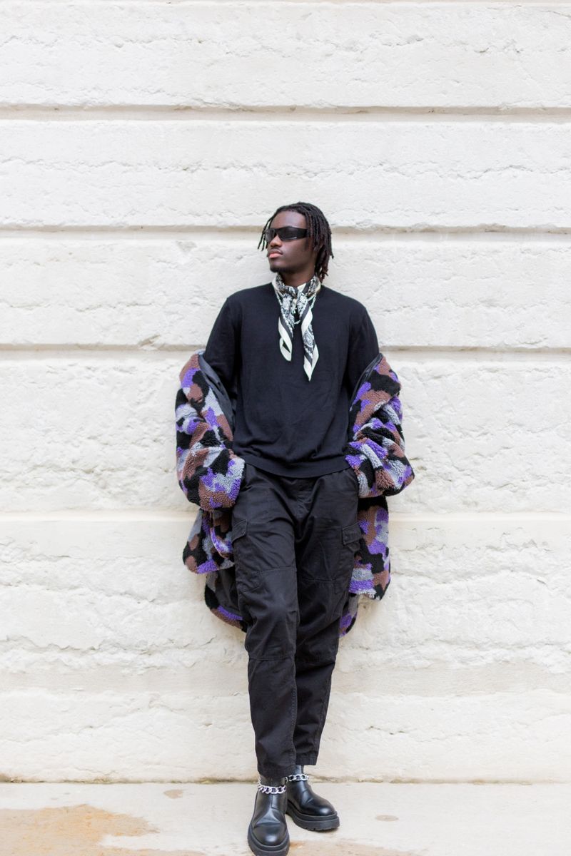 Young black man walking around town in fall.