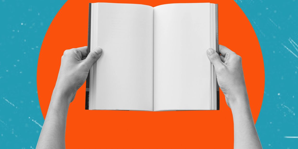 Hands holding an open book with blank pages against a colorful background.