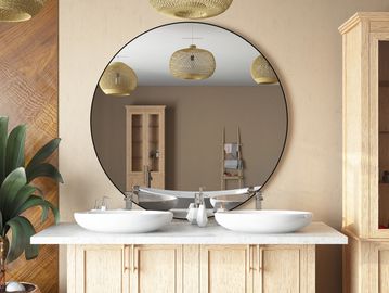 Elegant bathroom with a large round mirror and dual sinks.