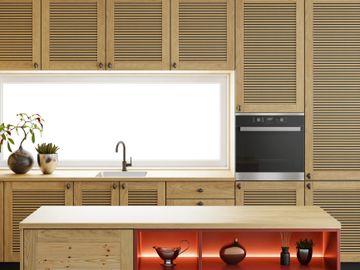 Modern kitchen with wooden cabinets and illuminated shelves in island.