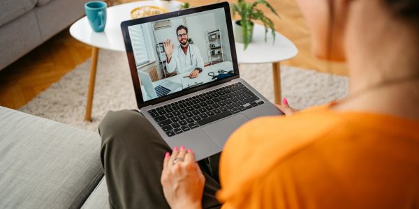Woman having a video consultation with a doctor on her laptop.