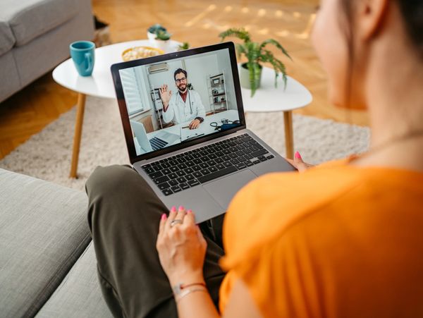 Woman having a video consultation with a doctor on her laptop.