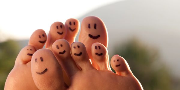 Smiley faces drawn on toes, creating a playful and cheerful vibe.