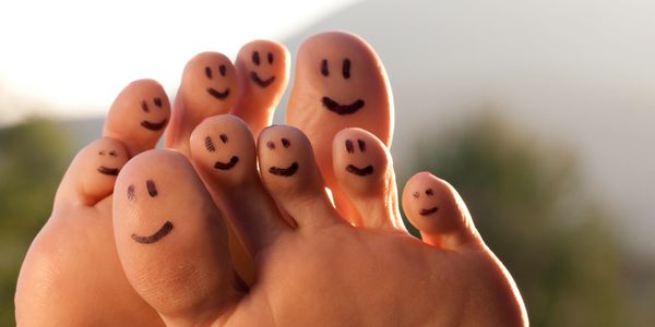 Smiley faces drawn on toes, creating a playful and cheerful vibe.