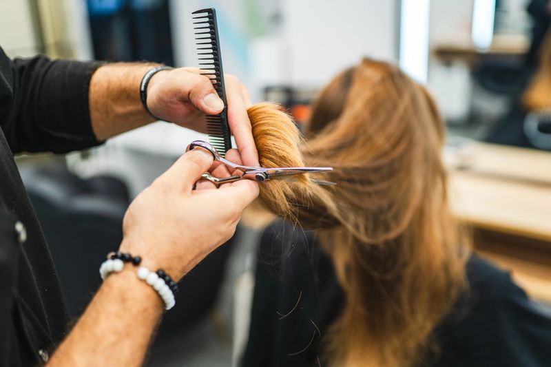 Beautiful young woman getting her hair cut