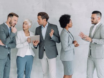 Five professionals in suits engaged in discussions in a modern office.