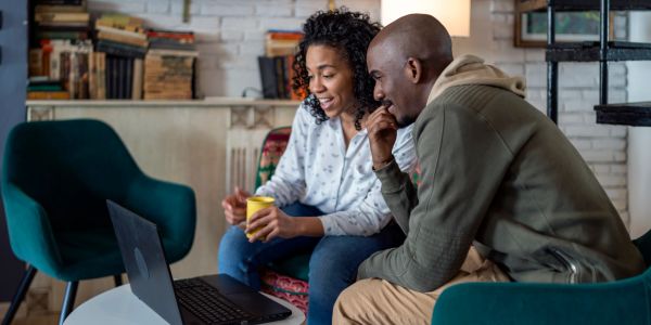 Two people looking at a laptop and smiling.