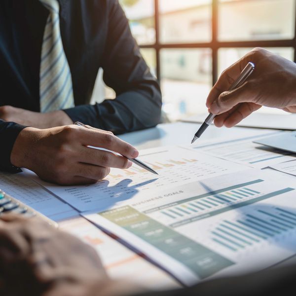 Two professionals analyzing financial charts and data in a meeting.