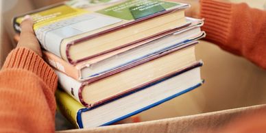A person holding a stack of books