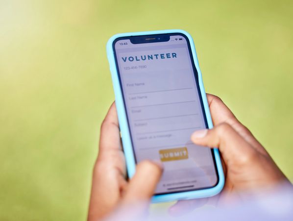 Person filling out a volunteer sign-up form on a smartphone with a blue case.