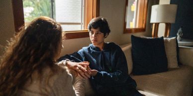 Two people having a serious conversation on a couch.