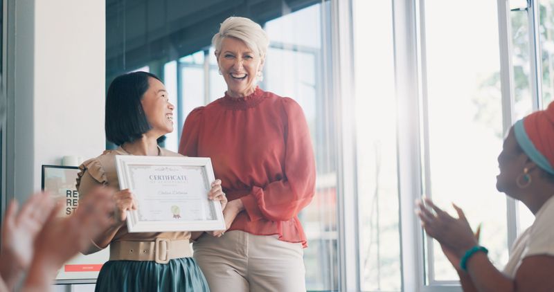 Applause, award and success with business woman in meeting for goal, thank you and winner. Celebration, praise and promotion with business people and certificate for support, achievement and branding
