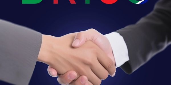 Two people shaking hands in a professional setting with BRICS logo above.